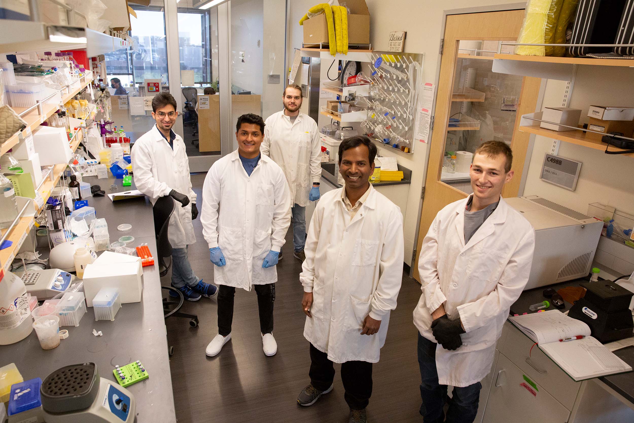 Azul Varman and four other researchers pose for a photo in Varman's lab