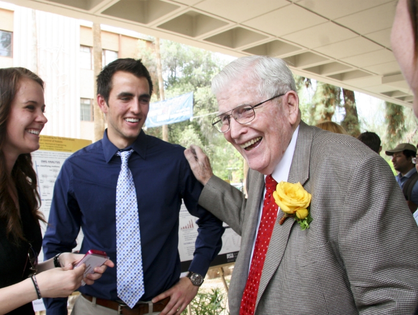 Two students laugh with Ira Fulton.