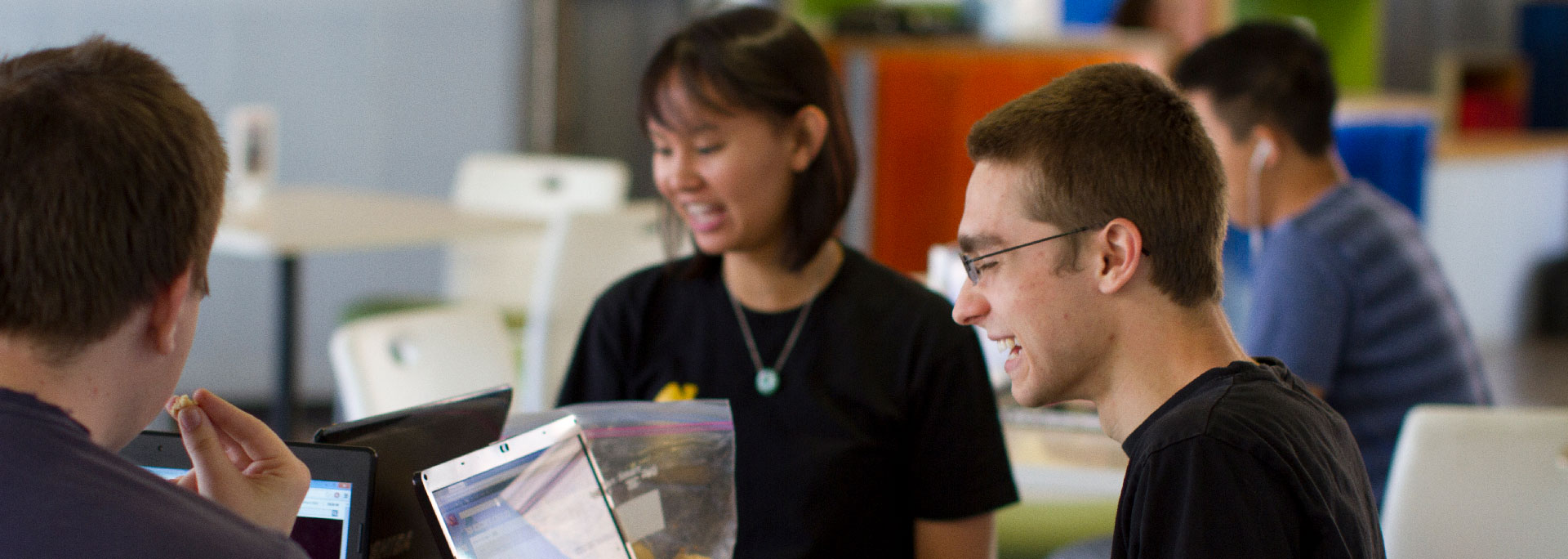 Three students work and laugh together