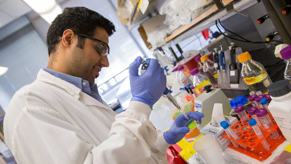 A man in a lab coat does an experiment.