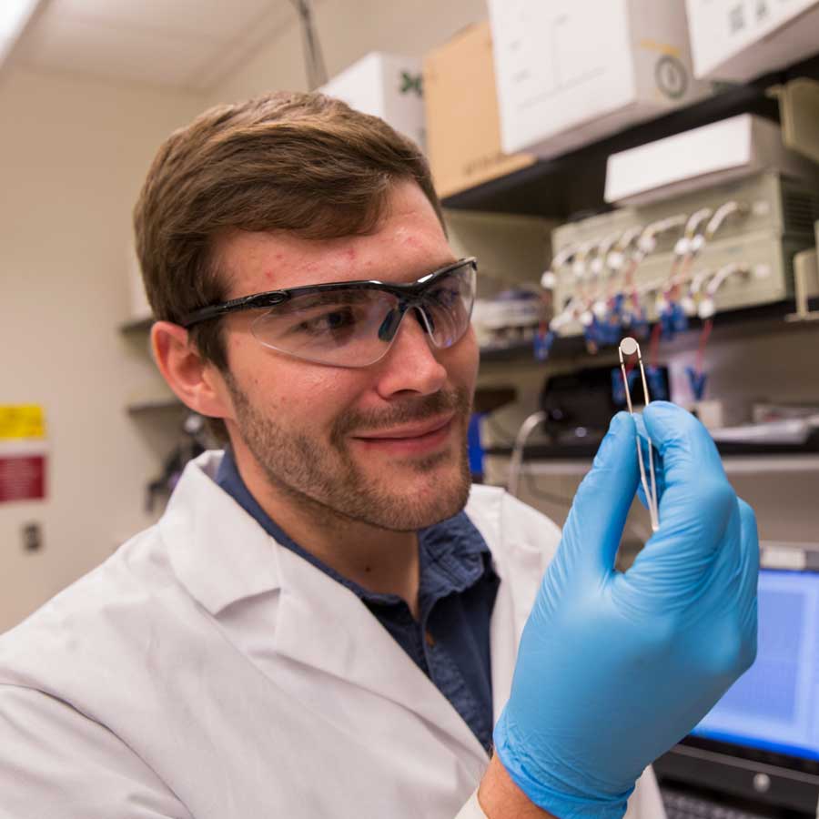 A man in a lab coat does an experiment.